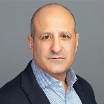 The image shows a professional headshot of a middle-aged man with a shaved head, wearing a dark blazer over a light blue checkered shirt, against a gray background. The post suggests this is Joseph Chalom, CEO of Sharplink, who is pictured here alongside his prediction that the majority of public companies will be tokenized within the next few years.