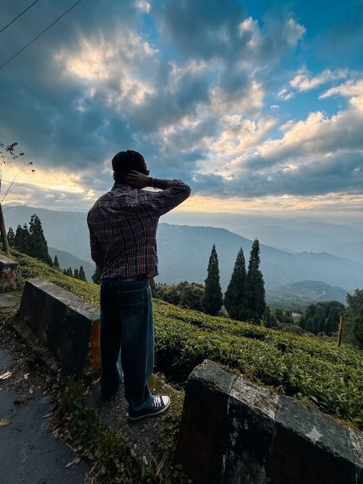 A man stands overlooking a scenic mountain landscape and lush tea plantations at sunset, gazing out into the distance—perfectly complementing a peaceful "Good Afternoon web3 fam" greeting.