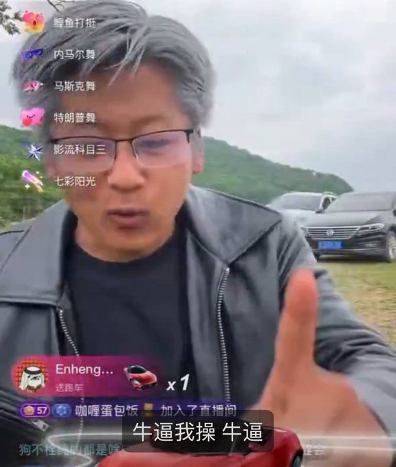 The image features a man wearing glasses, standing outdoors with his hand raised in front of him. The background includes cars parked nearby, suggesting that they might be at an event or gathering. The caption for this image reads "今日快讯（由HK雷氏小N为您播报共计820wu 2:韦驮在伊丽莎白响应招收了第三位徒弟大桃", which translates to "the man is wearing glasses and has his hand raised".