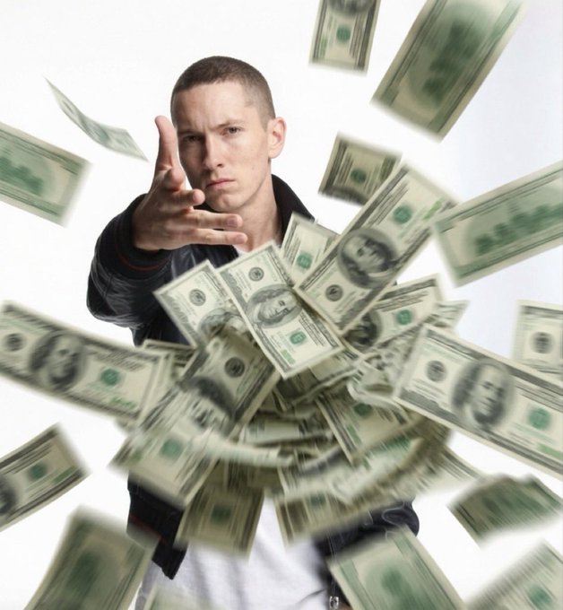 A young man reaching toward the camera as US dollar bills rain down around him against a white background.