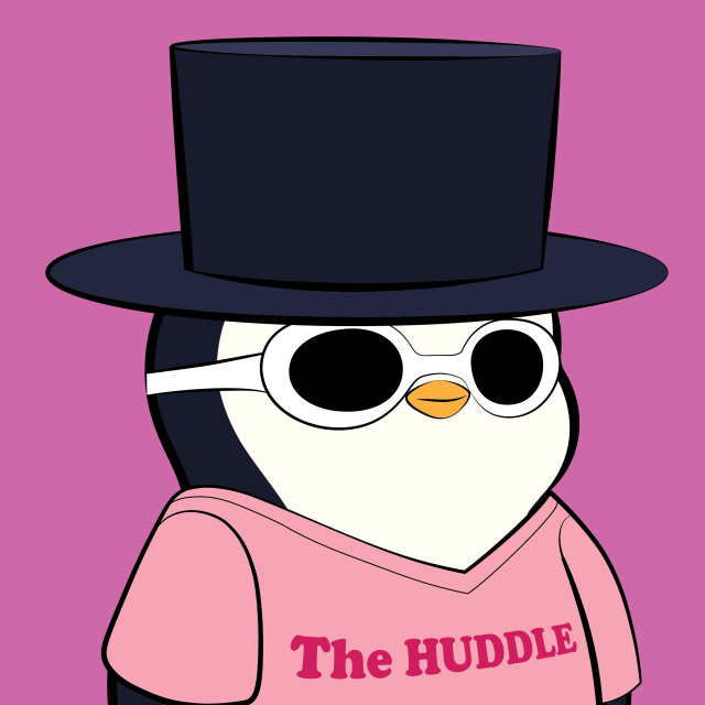A cartoon penguin wearing a large dark blue top hat, white sunglasses, and a pink shirt reading 'The HUDDLE' stands against a solid pink background.