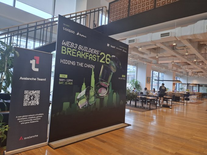 Banners for "Web3 Builders' Breakfast 26 - Hiding the Chain" and the Avalanche Team are displayed in a modern co-working or cafe space.