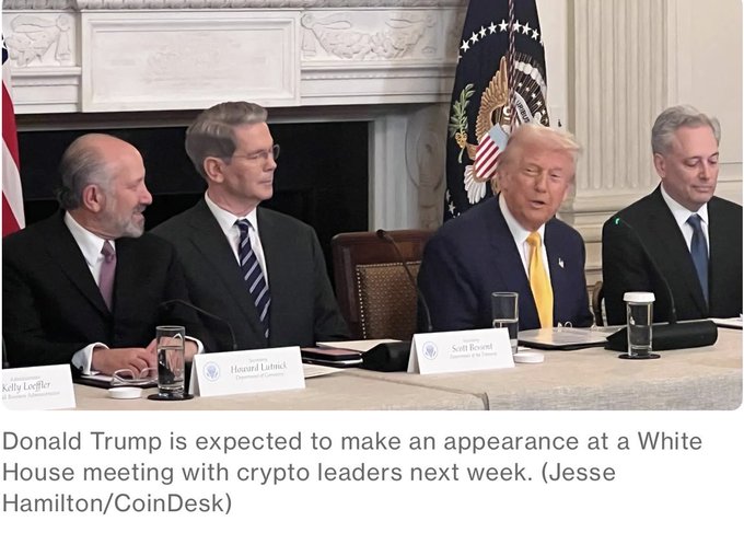 President Donald Trump sits at a White House meeting table alongside crypto and business leaders, including Secretary of Commerce Howard Lutnick and David Sacks, with nameplates for "Kelly Loeffler" and others visible, ahead of an expected August 19 gathering with cryptocurrency CEOs and tech executives.