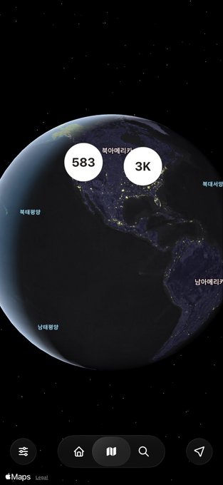A dark view of Earth from space displayed on Apple Maps showing city lights in North America and South America, with overlaid labels including '583 북아메리카' and '3K' in circular bubbles, and Korean text labels for various regions.