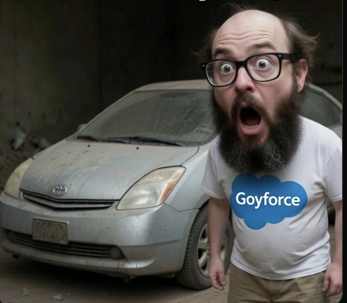 A man with glasses and a beard wearing a 'Goyforce' t-shirt stands with a shocked expression in front of a dusty silver Toyota Prius in a garage.