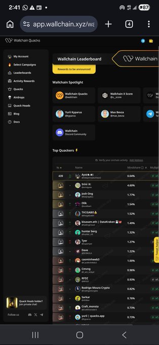 The image shows a phone screen displaying a website called "Wallchain" with a black background, yellow text, and a list of numbers arranged vertically. The website appears to be a leaderboard for some game or app, possibly related to cryptocurrency mining. The numbers on the screen are not clearly visible due to the dark background, but they seem to represent scores or ranks in the context of the game or app being displayed.