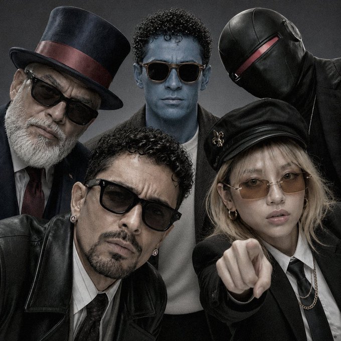 The image features five people posing for a picture with their hands outstretched towards the camera. The group consists of four men wearing suits and ties, one man wearing sunglasses, and another person wearing a black mask. They are all dressed formally, indicating that they might be attending an event or gathering. The post includes text such as "its 4 AM Early to get erm boys hotmaxxing #Hotemin chilling across TLs @avax hitting the candles green Looks like man been starting the day fresher than yesterday, isn'