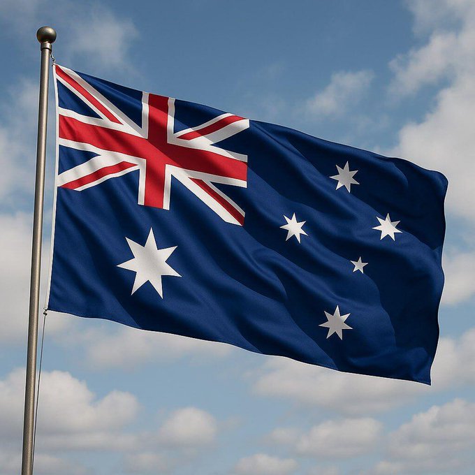 The image shows the Australian national flag waving against a cloudy blue sky, featuring the Union Jack in the upper left corner and the white Southern Cross stars on a blue field. The flag visually ties to the accompanying story about an AI agent breaching Australian government systems, symbolizing the country at the center of the reported incident.