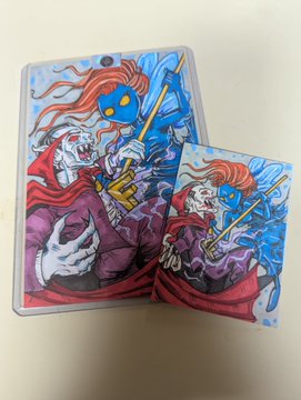 Two hand-drawn or printed illustrations of a zombie-like figure with red hair, a blue mask, and a purple suit, with one version mounted in a clear plastic sleeve.