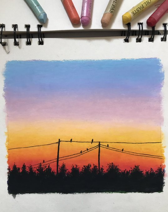A sketchbook page showing an oil pastel drawing of a sunset sky with birds perched on power lines above a silhouetted treeline, with several pastels scattered at the top.