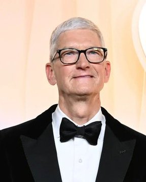 The image shows a man with gray hair, wearing black-framed glasses, a black tuxedo, white dress shirt, and black bow tie, appearing to be at a formal event. The accompanying post uses this image of Tim Cook, Apple's CEO, to make a crude joke about betting markets, implying that the Jewish CEO's position at the company would negatively affect the company's value.