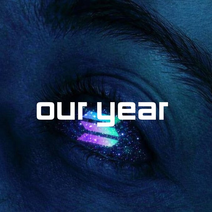 A close-up of an eye with a cosmic galaxy reflection in the iris, overlaid with stylized text 'our year'.
