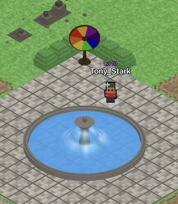 An isometric video game scene featuring a character named 'Tony_Stark' at Lvl 10 standing near a colorful spinning wheel, a fountain, and some ruins on a tiled plaza.