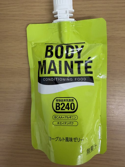 The image features a green bag of food, possibly a protein bar or snack, placed on top of a wooden surface. The packaging appears to be Japanese, with the text "BODYMAINTE" written on it. This suggests that the product is likely from Japan and may have cultural significance in the country where it was produced.