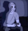 A figure wearing a pale, smiling mask sits indoors holding a game controller, appearing isolated in a dimly lit room. The image humorously contrasts with the post's message about going outside to feel good, instead depicting a stereotypical "doomer" or basement-dwelling gamer persona.