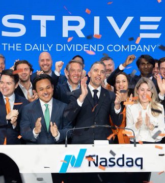 A group of people are celebrating on the Nasdaq trading floor under a large "STRIVE THE DAILY DIVIDEND COMPANY" banner. This image likely depicts a celebratory moment for Strive, a public company that has recently invested heavily in Bitcoin.