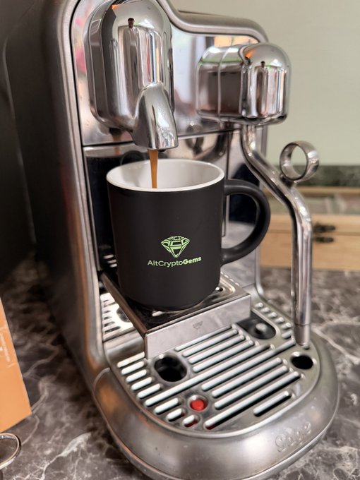 A chrome espresso machine brews fresh coffee into a black mug labeled "AltCryptoGems" alongside a diamond logo, perfectly pairing with a Monday morning motivational post signaling new opportunities for the week ahead.