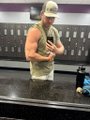 A small, blurry image showing a person in a green tank top and cap sitting in front of some equipment.