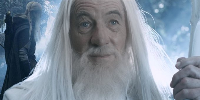 An elderly wizard with long white hair and beard, resembling Gandalf, holds a glowing staff in a forest setting.