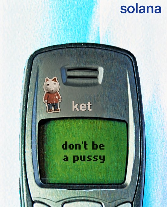 A retro-style flip phone meme features the text "ket don't be a pussy" displayed on its green screen, with a small cat character sticker and "solana" branding at the top, humorously illustrating the "$KET" ticker's "DBaP" (don't be a pussy) mantra from the caption.