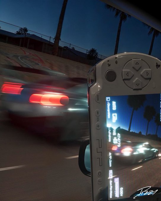 A handheld gaming device (PSP-style) displaying a racing game in real-time as a sports car speeds by at dusk on a palm tree-lined road (signed 'JBzari').