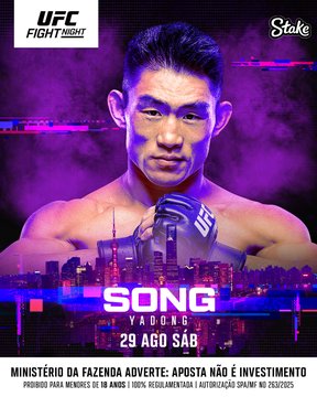 This image is a promotional graphic for a UFC Fight Night event sponsored by Stake, featuring Chinese mixed martial artist Song Yadong with the text "SONG YADONG" prominently displayed along with the date "29 AGO" (August 29). A disclaimer in Portuguese notes that the Ministry of Finance warns that betting involves risk, applicable to users over 18 with responsible gambling practices. The graphic directly relates to the accompanying post by promoting the main fight against UNMGdv at #UFCXangai, highlighting Song Yadong as a featured competitor on the card.