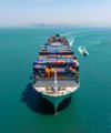 A traditional multi-tiered tour boat sails through turquoise ocean waters.
