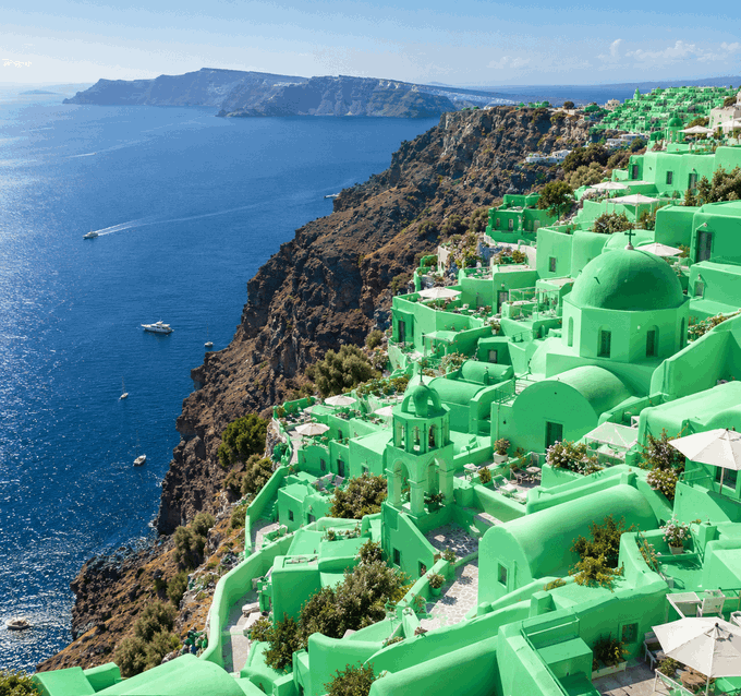 A scenic view of Santorini-like cliffside buildings that have been edited to be entirely bright green, overlooking the blue sea.