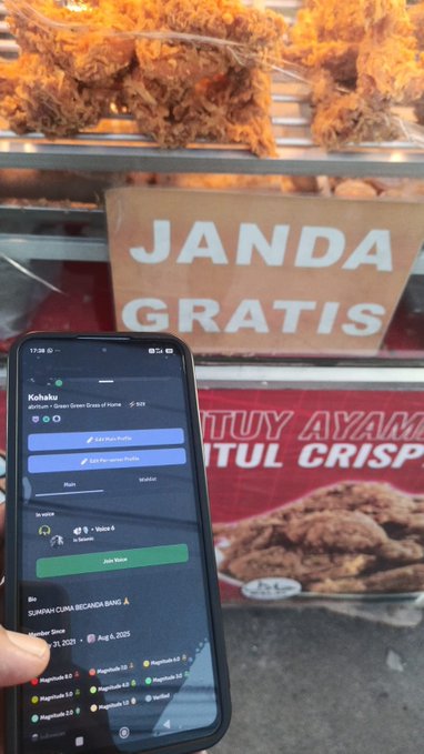 A person holds a phone displaying the Kohaku app showing ratings for 'JURAGAN CUMI BECANEG BANG A' at a food stall with fried chicken and a 'JANDA GRATIS' sign.