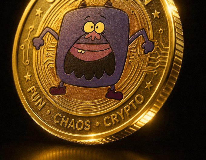 The image features a gold coin with a cartoon character, specifically a purple monster or troll, depicted on it. The coin has a funny face and appears to be in good condition. The text "fun chaos" can also be seen on the coin. This coin is likely used as a form of payment for goods and services, but its unique design makes it an interesting and eye-catching item.