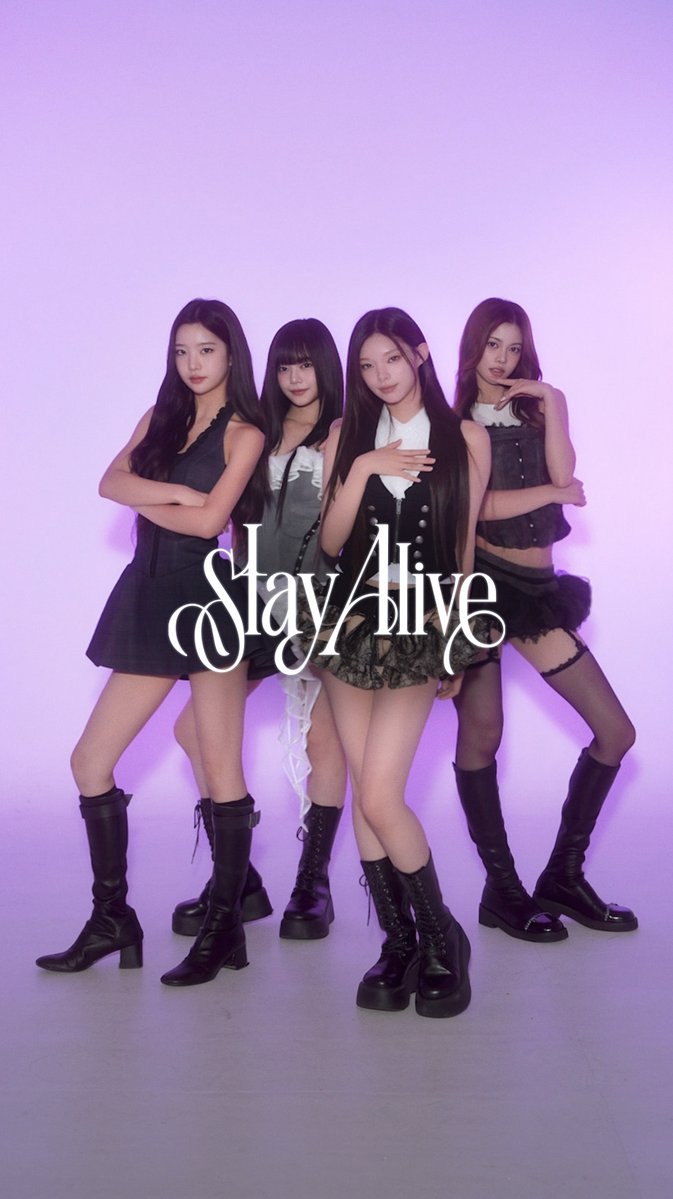 A promotional photo of the K-pop group BLACKPINK for their song 'Stay Alive,' featuring all four members (Jisoo, Lisa, Jennie, and Rosé) posing in black outfits against a purple background.