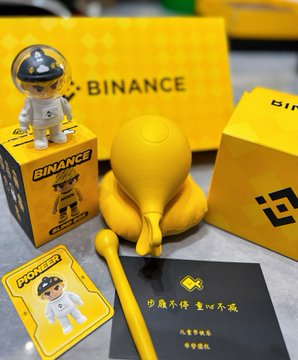 The image features a collection of items, including a yellow toy robot, a yellow balloon, and some cards or stationery with Chinese characters. The objects are arranged next to each other, creating an interesting visual display. The post includes text that reads "离了币安谁还把我当小孩？", which seems to be a reference to the toy robot and possibly the balloon in the image. 

The cards or stationery with Chinese characters might suggest that this post is related to an event, celebration, or cultural exchange involving people from different countries. The combination of these items creates a unique blend of elements, showcasing creativity and diversity within the context of the post's content.