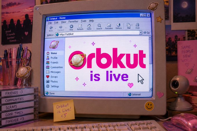 A retro 3D-rendered scene of an old desktop computer displaying "Orbkut is live" on its browser, surrounded by Y2K-era decor including sticky notes reading "Orbkut is live! <3" and "SAME PEOPLE NEW WORLD <3".