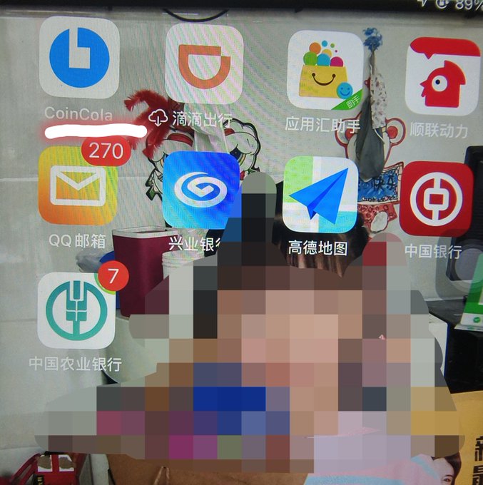 A smartphone home screen displaying Chinese app icons including CoinCola, QQ Mail, and Amap, with a heavily pixelated rectangular area obscuring the center of the screen.