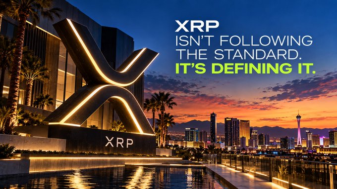 An advertisement featuring a large XRP logo sculpture at night with text reading 'XRP ISN'T FOLLOWING THE STANDARD. IT'S DEFINING IT.'