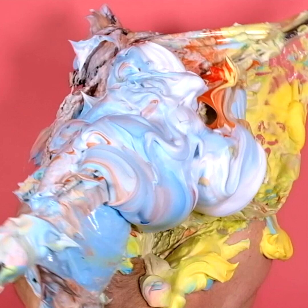 The image features an abstract painting of a person's head with a face made out of frosting or paint splatters. The colors used are primarily blue, green, yellow, and orange. The background appears to be pinkish-red, which contrasts with the vibrant colors of the face. The post also mentions that the artist is interested in creating custom colors for their work, such as a green and purple one, a blue and yellow one, or even an abstract piece like this one.