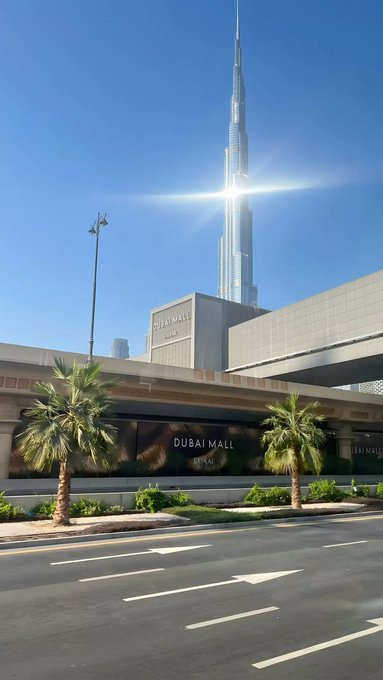 The Burj Khalifa towers above the Dubai Mall on a clear, sunny day. The image ties to the "GM" (Good Morning) post as a cheerful morning greeting featuring one of Dubai's most iconic landmarks bathed in bright sunlight.