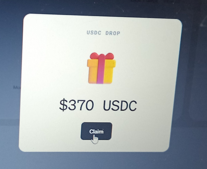 A computer screen displays a pop-up modal titled 'USDC DROP' with a gift box icon, showing a $370 USDC reward and a 'Claim' button being clicked by a cursor.