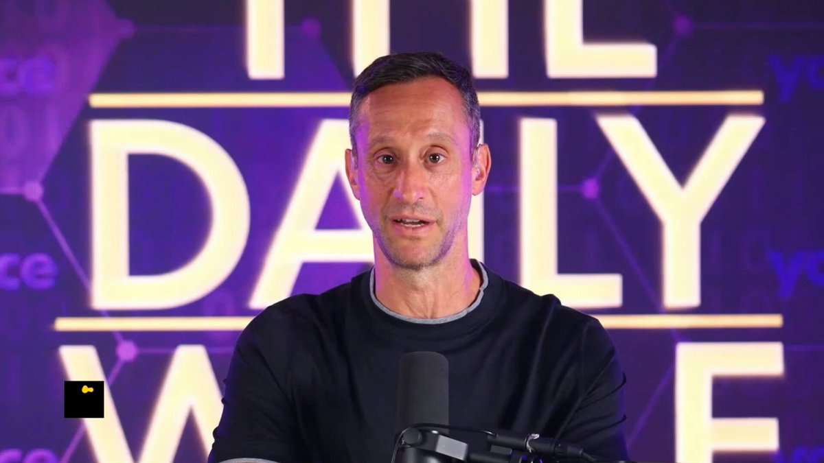 The image features a man wearing a black shirt standing behind a microphone, likely at a podcast recording session or live event. The background of the image is purple with white text that reads "THE DAILY Value", suggesting that this could be an interview or discussion about the value of Bitcoin and other cryptocurrencies.