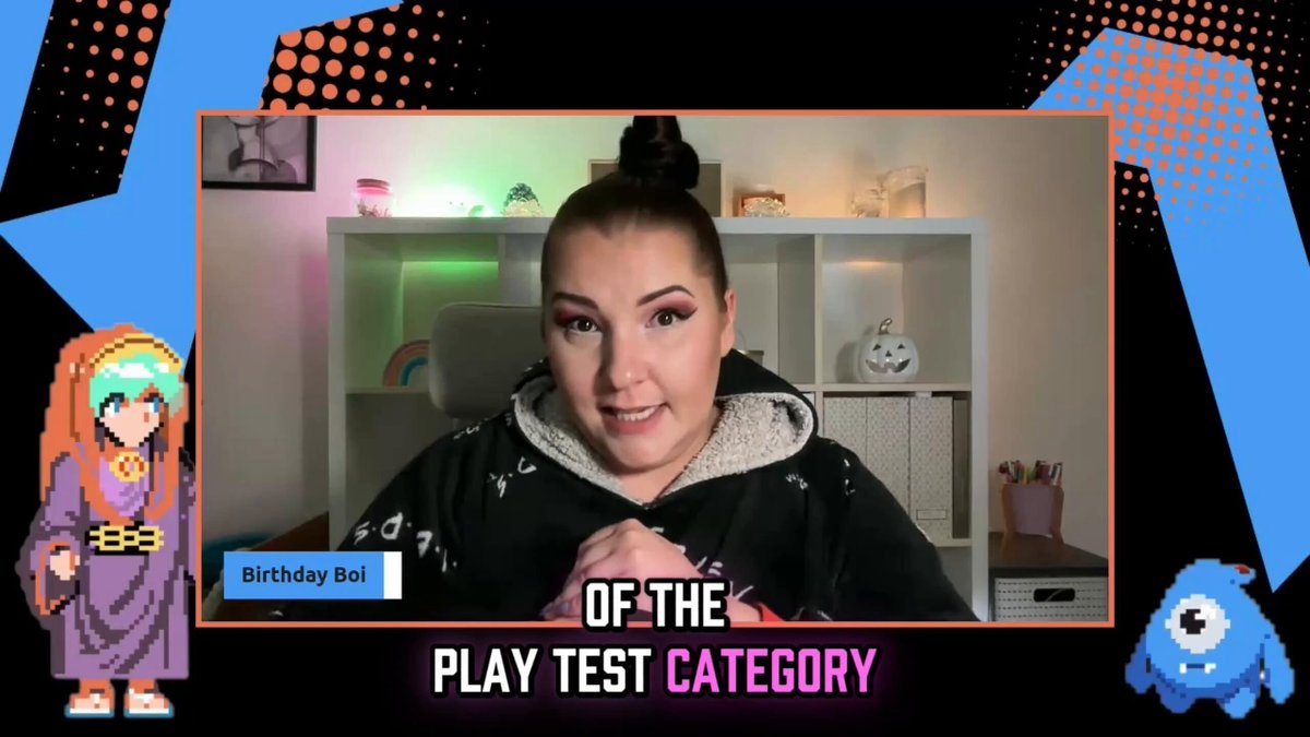 The image shows a woman sitting at a desk with a computer screen in front of her. She appears to be participating in an online game or test, as indicated by the text "Of the Play Test Category". The background features a cartoon character and a blue and orange color scheme. There is also a small blue monster on the right side of the image.