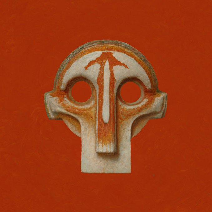 A close-up of an ancient-looking, stylized stone head sculpture with large hollow eyes and red markings on a bright red background.