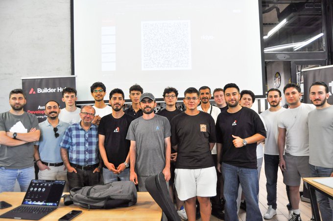 A group of approximately fifteen men poses for a photo in an office or classroom setting, with an Avast Developer banner visible on the left side behind them.