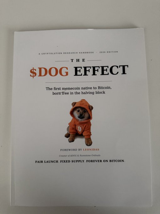 A book cover titled 'THE $DOG EFFECT: A CRYPTOLUTION RESEARCH HANDBOOK - 2026 EDITION' featuring a Shiba Inu in an orange hoodie, with a foreword by Leonidas, creator of $DOG & Runestone Ordinals.
