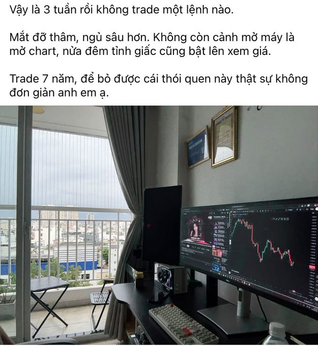 A social media post in Vietnamese describing a trader's struggle to stop opening charts, accompanied by a photo of a balcony setup with dual monitors displaying red downward-trending crypto charts.