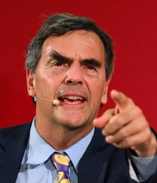 Tim Draper, a prominent venture capitalist, speaks passionately into a headset microphone, gesturing emphatically with his finger as he warns of imminent bank runs and predicts Bitcoin will rise "infinite" against the US dollar.