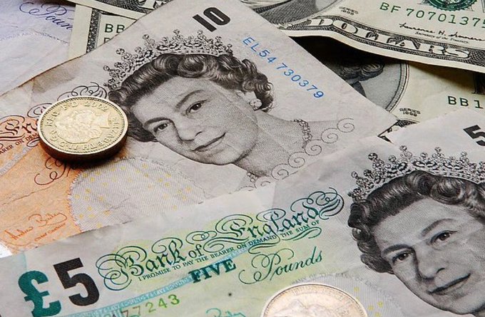 A close-up pile of British currency, featuring £5 and £10 notes bearing the portrait of Queen Elizabeth II, along with US dollar bills and gold coins.