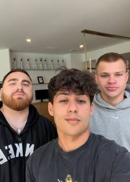 Three young men pose together for a selfie, with the individual on the left wearing a black Nike hoodie featuring white "NIKE" lettering, likely showing StableRonaldo, Jynxzi, and LosPollosTV before their hardcore Minecraft marathon. The caption's mention of Polymarket betting odds and the Ender Dragon challenge connects to the image of the three content creators preparing for or taking a break from their gaming event.