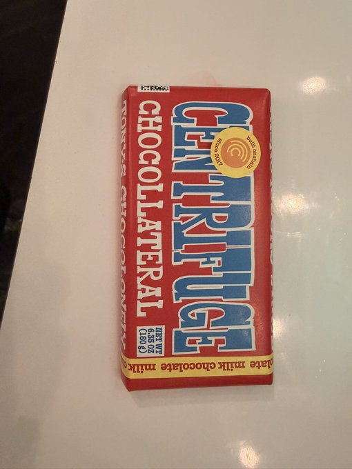 A Tony's Chocolonely chocolate bar in its red 'Choco Latéral' wrapper, labeled 'Bite into chocolate milk' with 100g net weight.