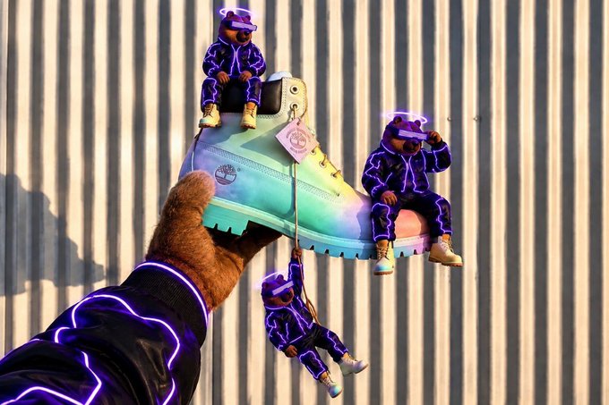 A person's hand, wearing a jacket with glowing purple lines, holds a colorful boot featuring three small bear figurines dressed in matching glowing purple outfits.