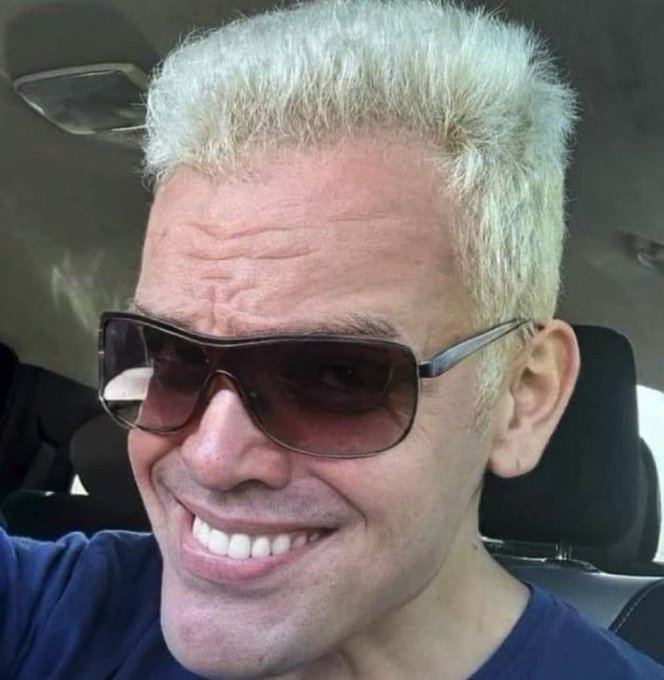 A smiling man with bleached blonde hair and aviator sunglasses takes a selfie inside a car, seemingly unfazed by the post's cautionary message about being caught in a bull trap during a bear market.